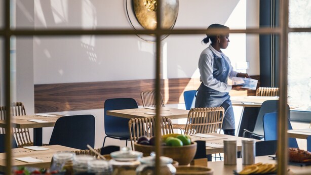 A restaurant interior with tables, chairs, and a waiter. - Select Porto (Porto)