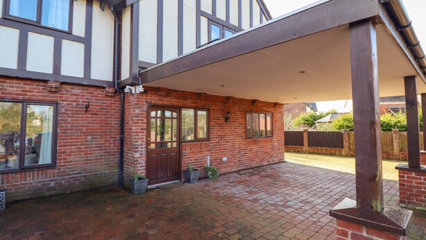 A two-story house with a covered patio area. - Maesbury Manor (Oswestry)