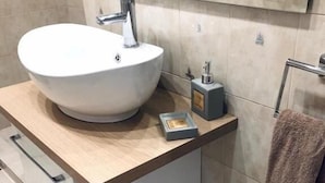 A modern bathroom with a large vessel sink, a towel rack, and a small soap dish. - Charming Apartment in Faliro (Palaio Faliro)