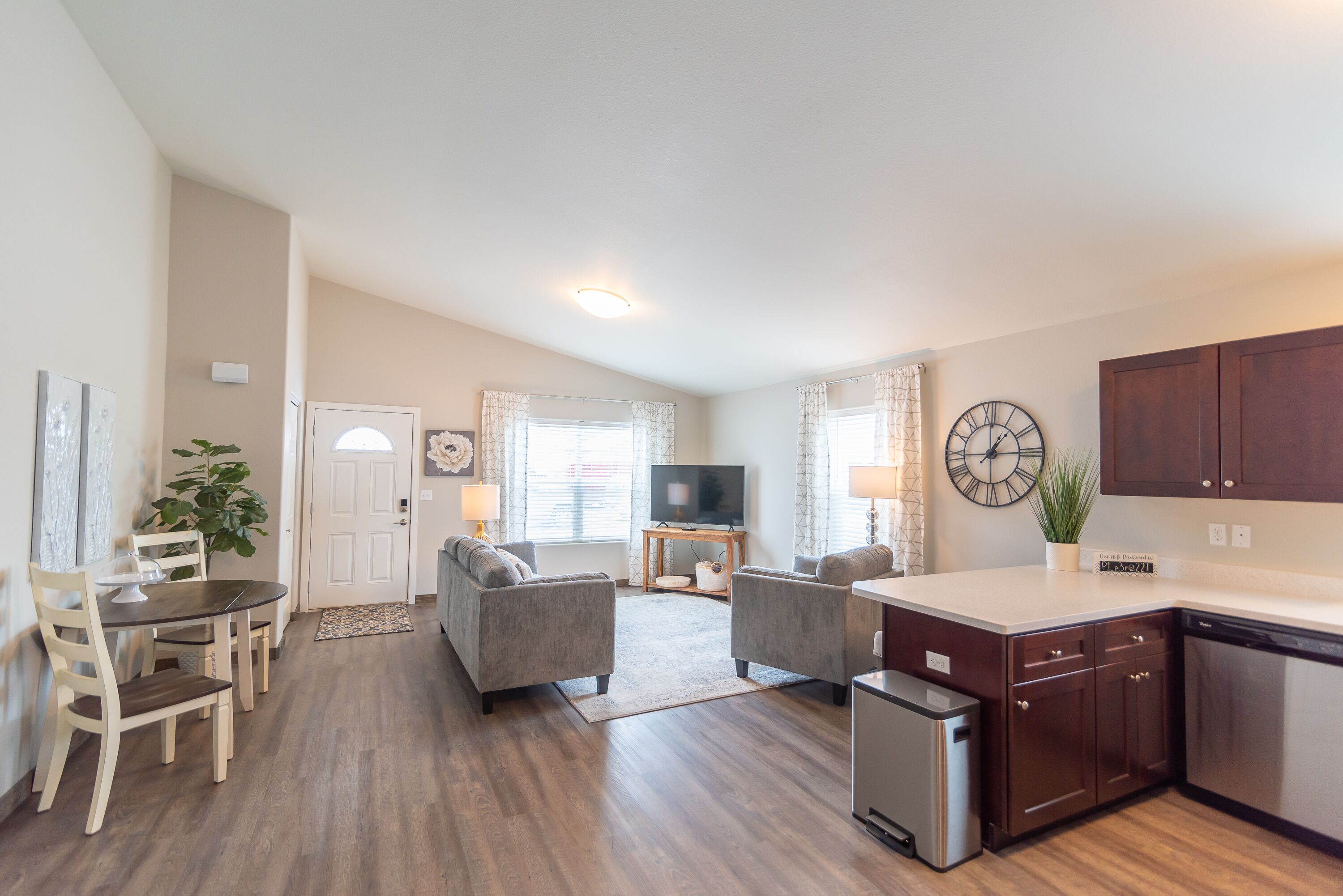 A modern living room with a sofa, TV, and dining area.