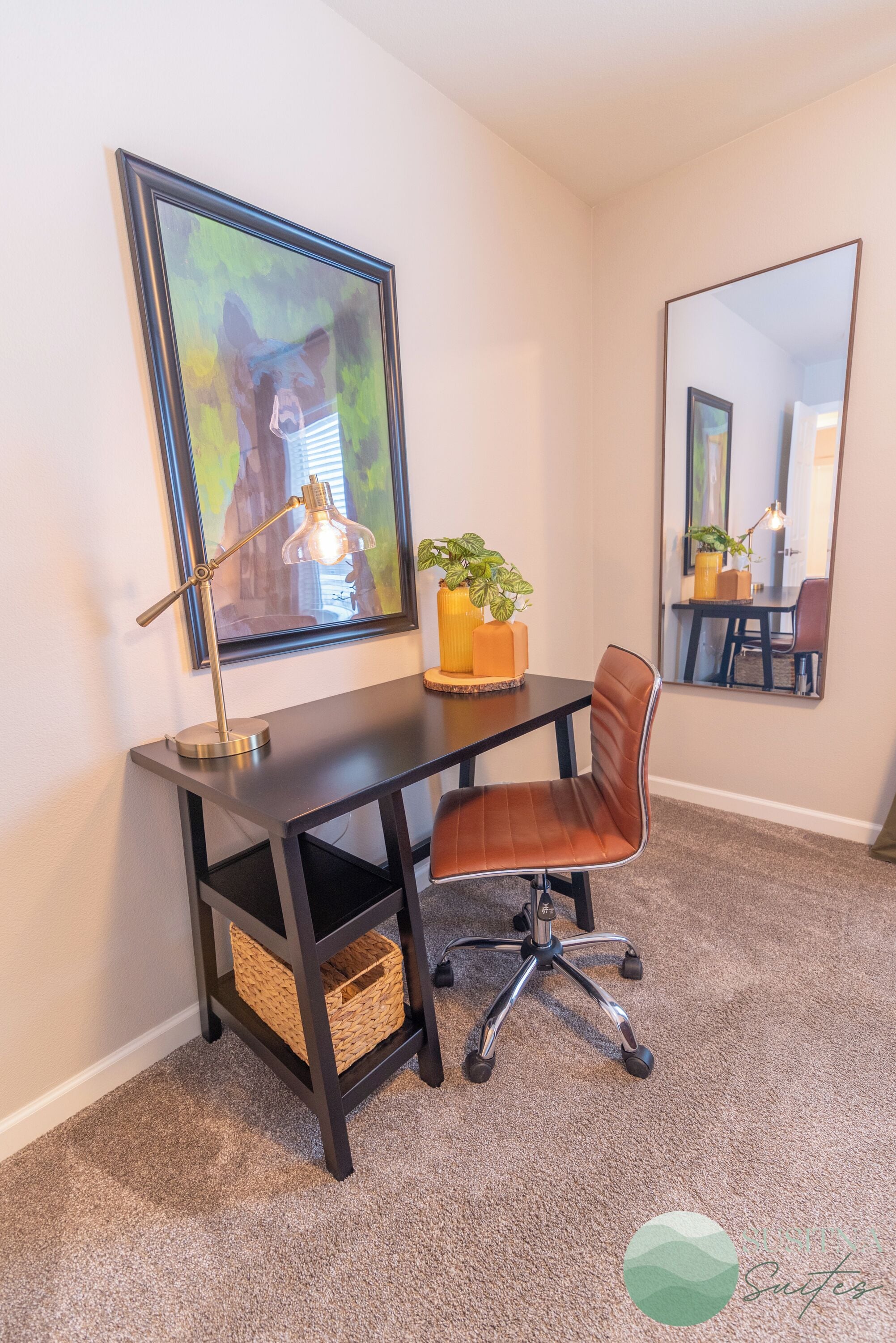 A modern office space with a desk, office chair, lamp, and decorative plants.