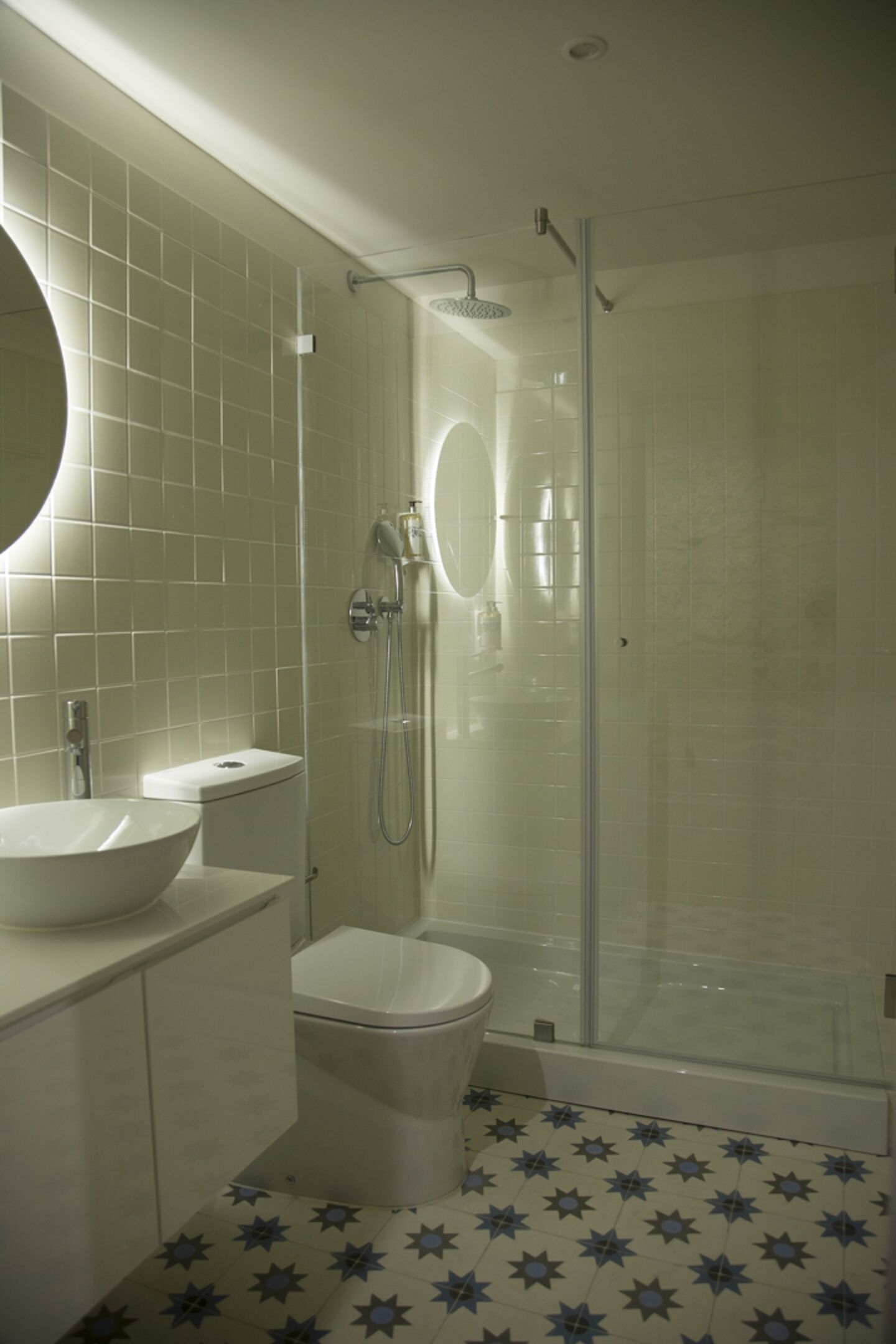 A bathroom with a white sink, toilet, and shower enclosure.