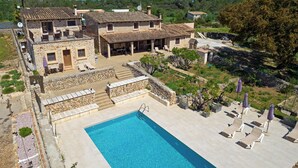 Une villa en pierre dotée d’une piscine, d’un espace extérieur aménagé et offrant une vue sur le paysage environnant.