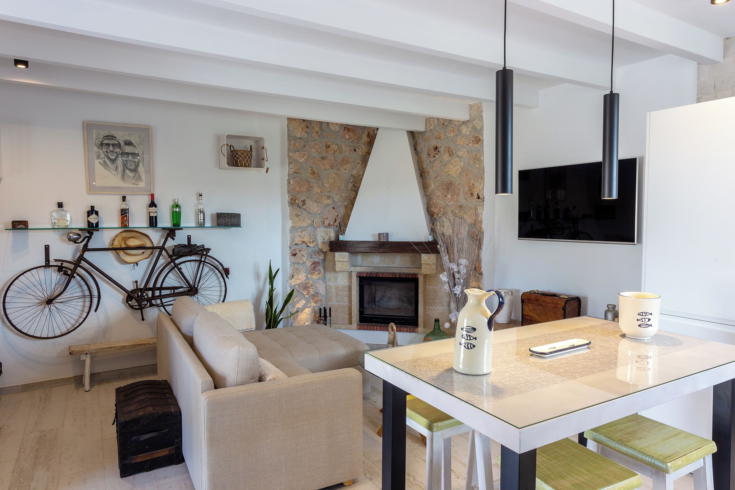 Een moderne woonkamer met een bank, een eettafel, een open haard en een televisie.