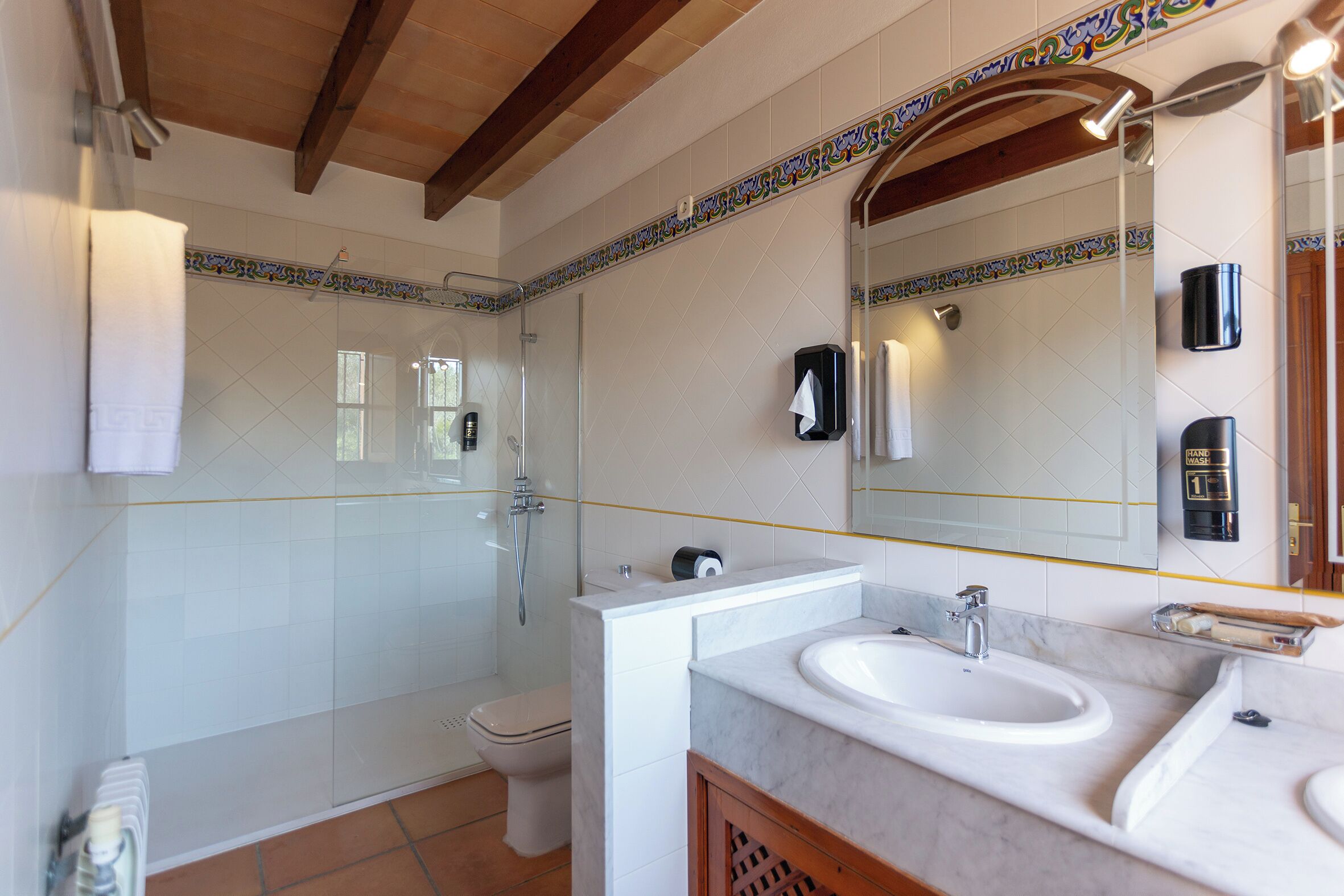 A bathroom with a shower, toilet, and two sinks.