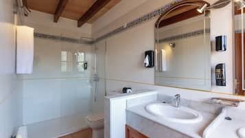 A bathroom with a shower, toilet, and two sinks.