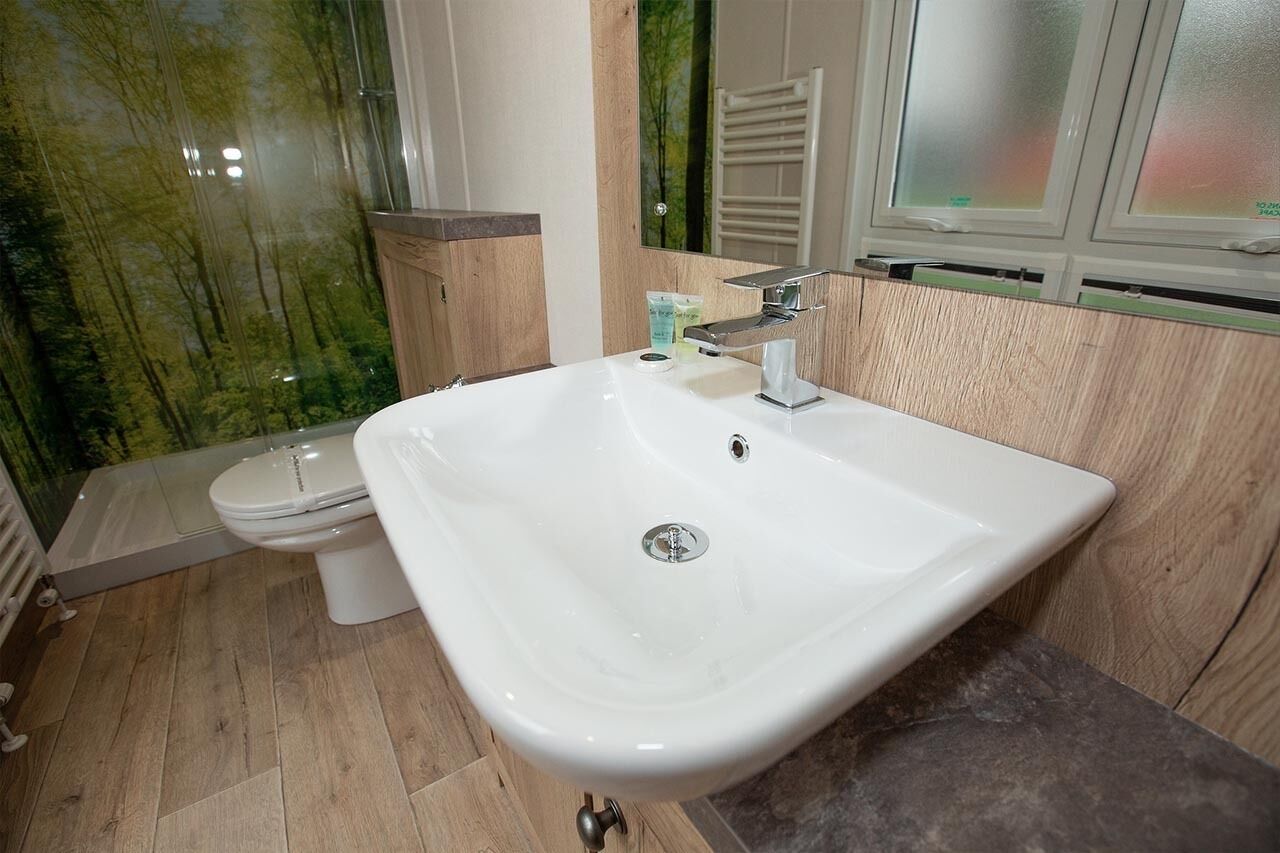 A bathroom with a white sink, a toilet, and a shower area.