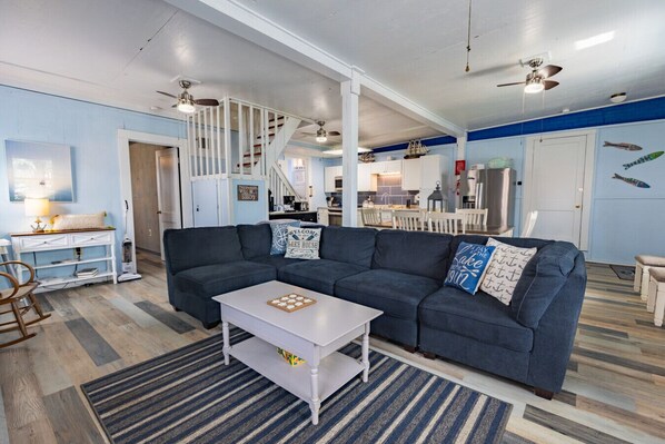 A living room with a dark blue sofa, a white coffee table, and a striped rug. - Marcaritaville at La · Marcaritaville at Lake Barkley (Kuttawa)