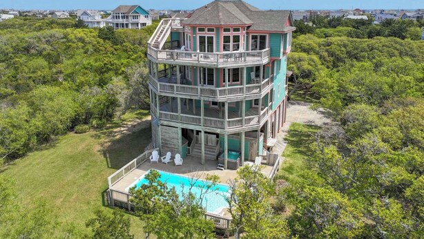 A multi-story house with a pool, surrounded by dense greenery. - Soundfront Dog Friendly Home w/ Pool, Hot Tub, Elevator, Private Sound Boardwalk (Avon)