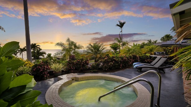 A hot tub with a view of the sunset, surrounded by lush greenery and palm trees. - Pineapple House: Ocean View Home in Keauhou Estates w/ Private Hot Tub, BBQ & AC (Kailua Kona)
