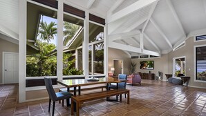 A spacious living area with a high ceiling, large windows, and a tiled floor. - Pineapple House: Ocean View Home in Keauhou Estates w/ Private Hot Tub, BBQ & AC (Kailua Kona)