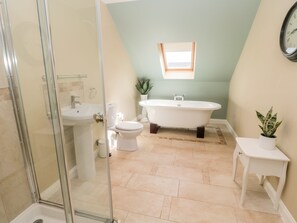 A bathroom with a freestanding bathtub, a sink, a toilet, and a shower area. - Calm Skies (Berwick-upon-Tweed)