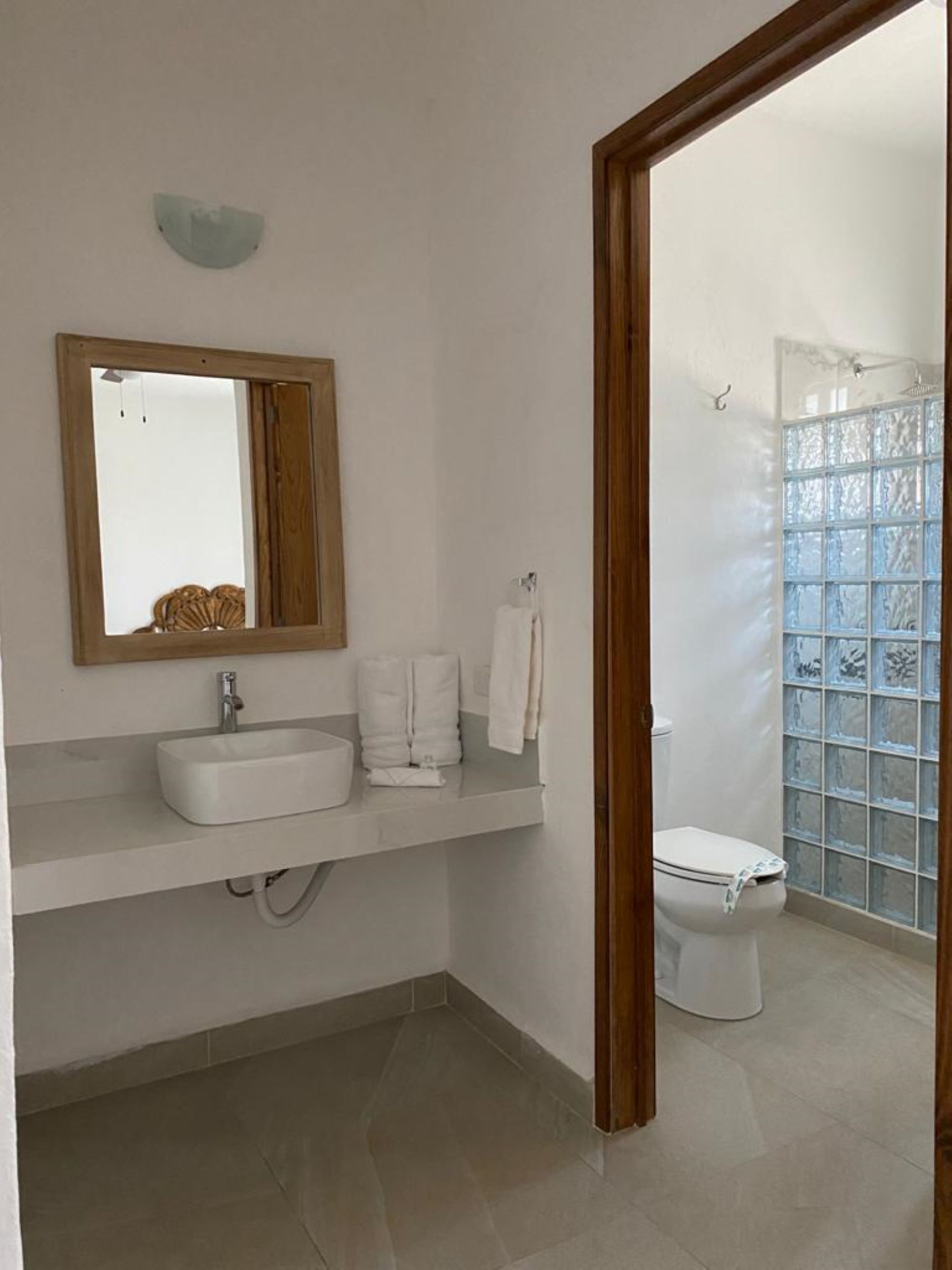 Une salle de bain avec un lavabo, un miroir et des toilettes.