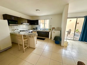 A modern kitchen with a central island, a built-in oven, and a dishwasher.