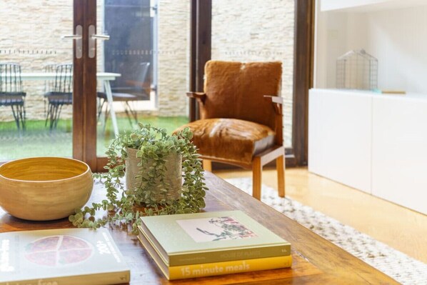A wooden table with a bowl, a book titled '15 minute meals', and a potted plant.
