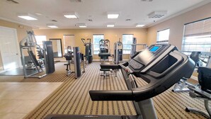 A gym with cardio equipment, weight machines, and a mirrored wall. - Big house with private pool near to Dinsey and other theme parks (Kissimmee)