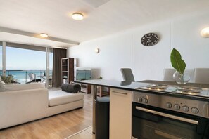 Een moderne keuken met een fornuis, oven en een eetgedeelte met uitzicht op de oceaan.