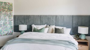 A neatly made bed with a grey headboard, two bedside tables with lamps, and a floral artwork on the wall. - 'the sticks' - Sleeps 10, 5 Ensuites, Pool, Fire (Upper Kangaroo River)