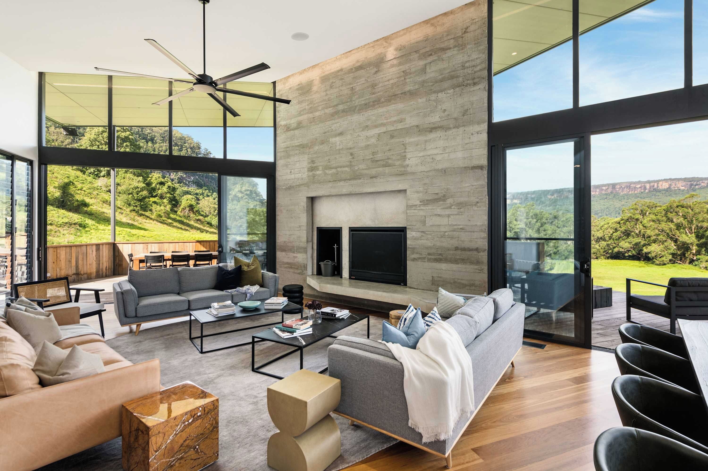 A spacious living area with a fireplace, large windows, and a view of the outdoors.