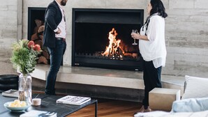 A modern living room with a fireplace, a sofa, a coffee table with books, and a vase with flowers. - 'the sticks' - Sleeps 10, 5 Ensuites, Pool, Fire (Upper Kangaroo River)