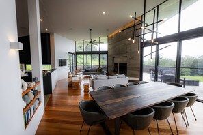 A modern interior with a dining area, sofas, and a fireplace.