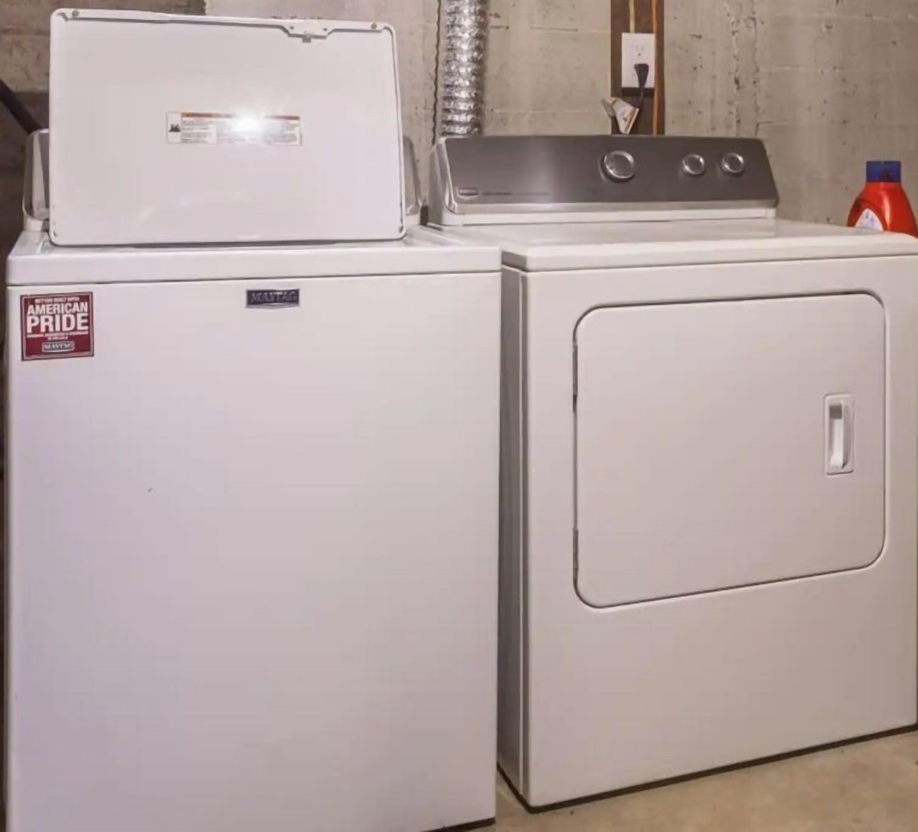 Un appareil compact combinant une machine à laver et un sèche-linge, avec une machine à laver à chargement frontal et un sèche-linge à chargement par le haut.