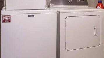 Un appareil compact combinant une machine à laver et un sèche-linge, avec une machine à laver à chargement frontal et un sèche-linge à chargement par le haut.
