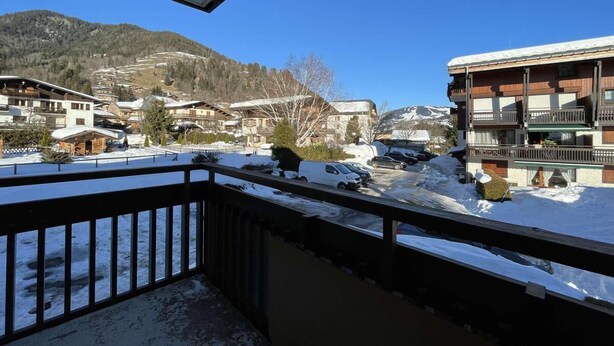 A balcony with a view of a snowy mountain and buildings. - 1st floor, balcony, parking, tv, ski locker, 29m², Praz sur Arly (Praz-sur-Arly)