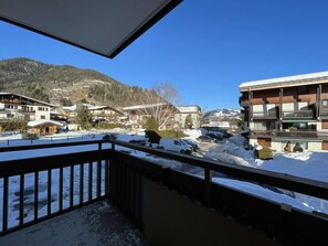 A balcony with a view of a snowy mountain and buildings.