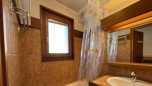 A bathroom with a bathtub, a window, a sink, and a mirror. - 1st floor, balcony, parking, tv, ski locker, 29m², Praz sur Arly (Praz-sur-Arly)