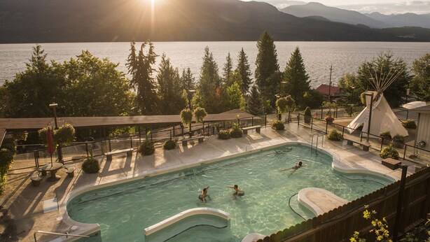 Una piscina con vistas a un lago y montañas.