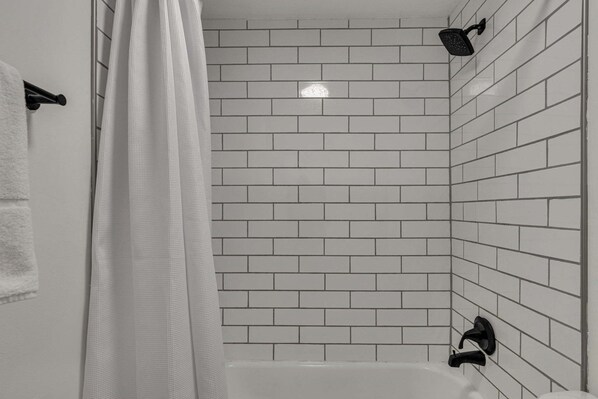 Bathtub, hair dryer, towels, shampoo