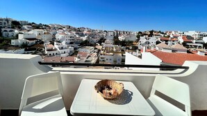 Un balcón con vistas a un pueblo densamente poblado de edificios blancos y tejados rojos.