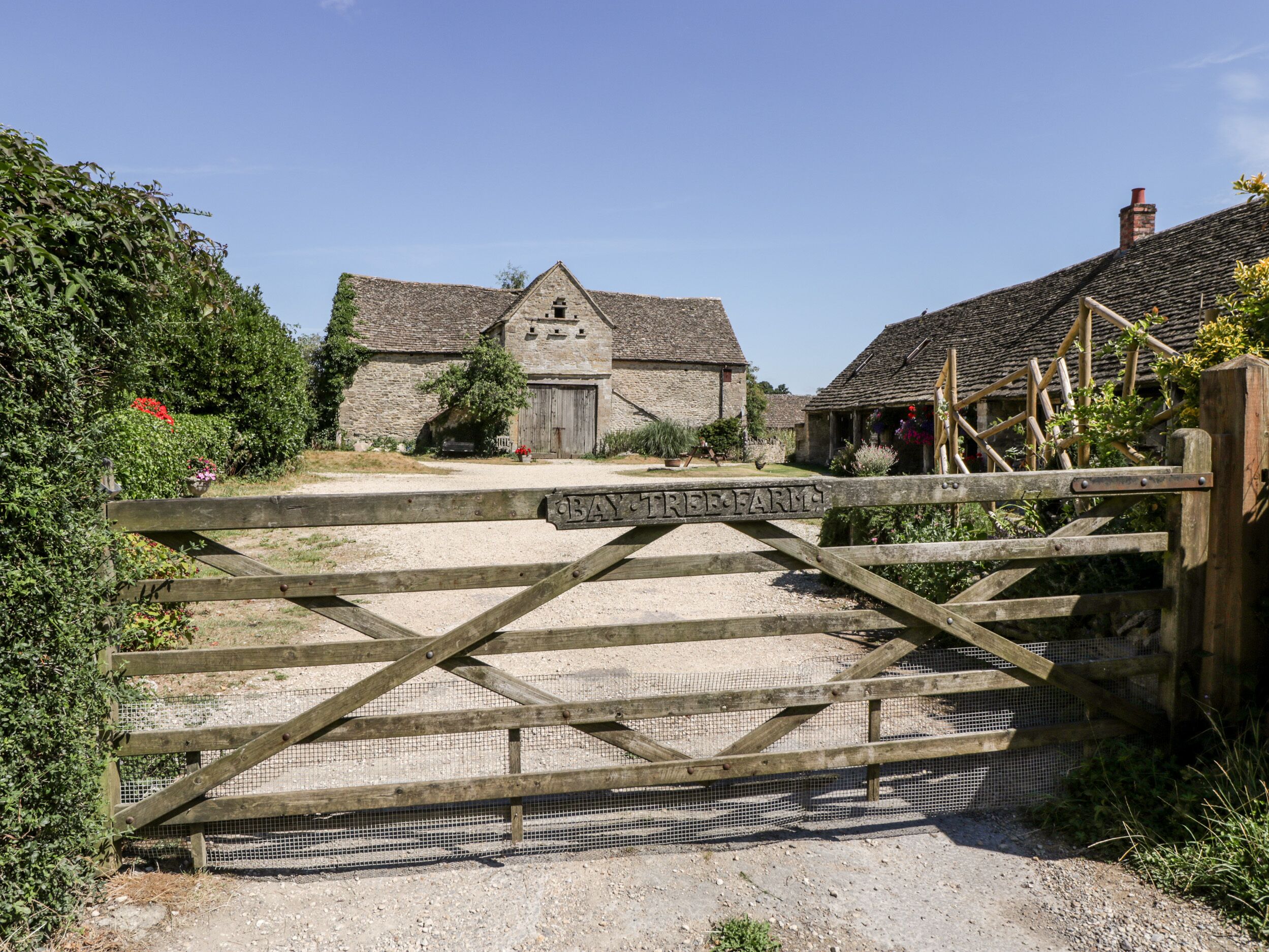 A rustic wooden gate with a sign reading "Bay Tree Farm."