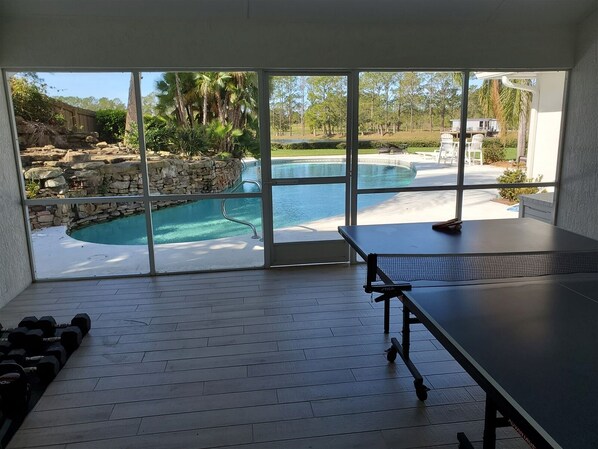 Enjoy a workout or game session in this room with a netted surface and dumbbells, then relax by the pool with a waterfall view.