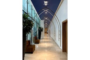 Experience the perfect blend of modernity and comfort in our stylish corridor, featuring a sleek design, glass walls, and a warm wooden paneling.