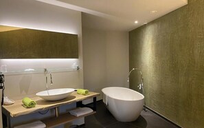 A modern bathroom with a large freestanding bathtub, a vessel sink, and a glass-enclosed mirror. - Eau de Roche (Durbuy)