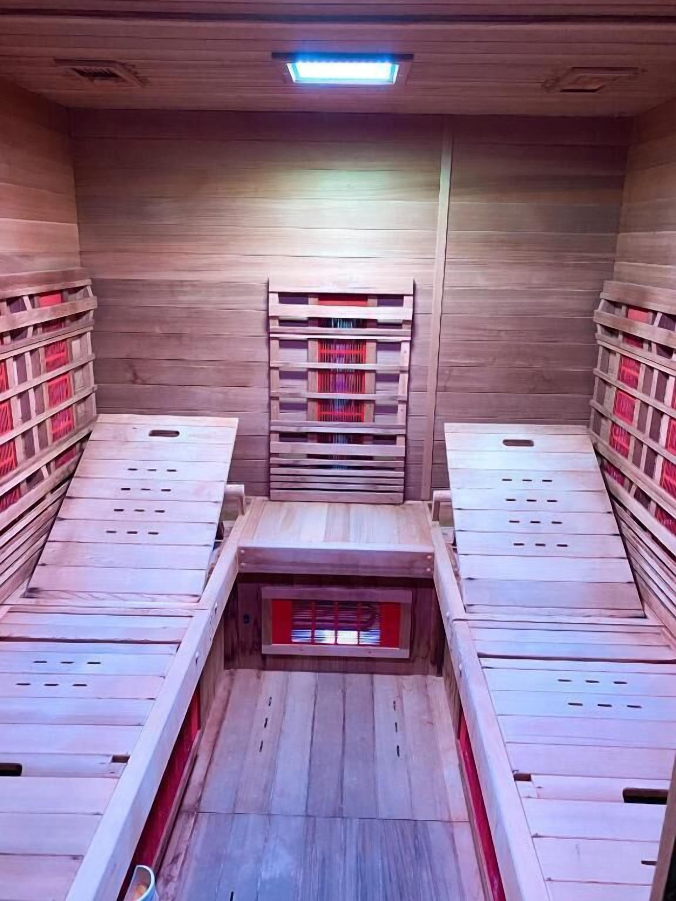 A room with wooden walls and a central wooden structure with shelves.