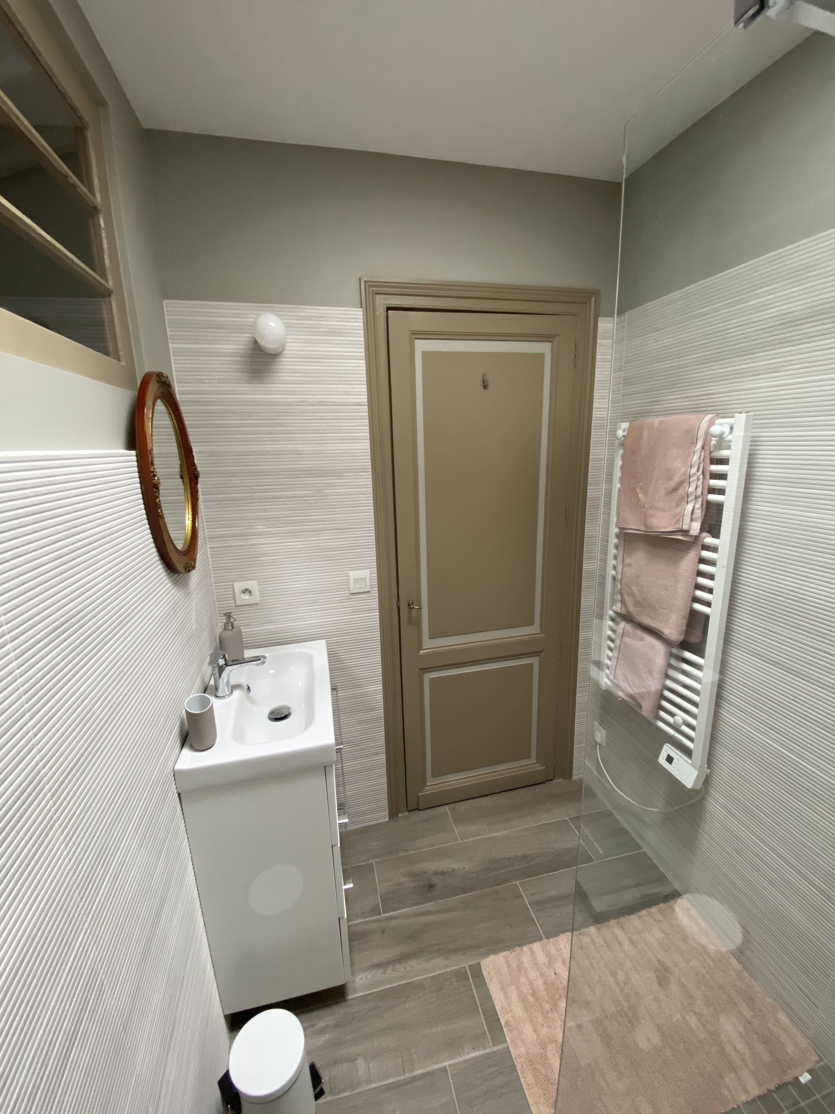 A bathroom with a sink, mirror, toilet, and towel rack.