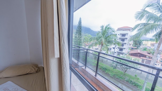 Un balcon donnant sur un quartier résidentiel, avec vue sur des immeubles et des palmiers.