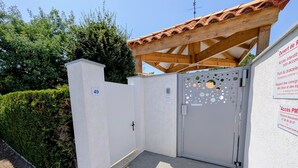 A gated entrance with a metal door, a number 49 sign, and a small overhang above the door. - Superb Vacation House With Garden And Terrace (La Tranche-sur-Mer)