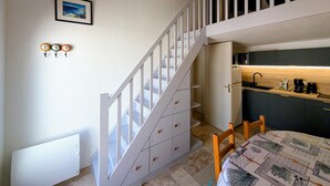 A staircase leading to a second floor, a kitchen area with modern appliances, and a dining table with a patterned tablecloth. - Superb Vacation House With Garden And Terrace (La Tranche-sur-Mer)