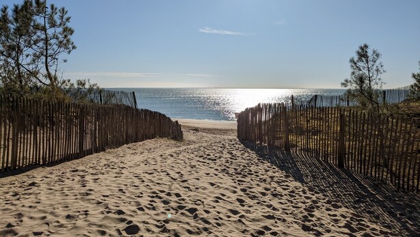 A sandy beach with a wooden fence leading to the ocean, under a clear sky. - Superb Vacation House With Garden And Terrace (La Tranche-sur-Mer)