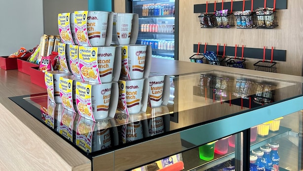 Zona de desayuno autoservicio con café instantáneo, cereales y aperitivos.