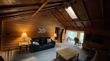 Cozy retreat with a high ceiling, exposed beams, and a comfortable sofa.