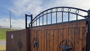 Een houten poort met metalen sterren en een 'Geen Toegang'-bord.