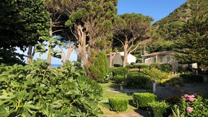 A coastal property with a garden, trees, and a view of the sea. - Welcome to Domaine U Pozzu (SISCO)