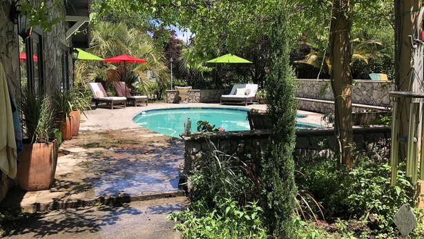 A backyard with a swimming pool, surrounded by potted plants and outdoor furniture. - Gated Estate-Master Bedroom w/Full Bath with Private Spa (Redwood Valley)
