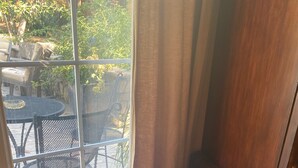 A wicker basket with pink items on a tiled floor near a window with a view of outdoor furniture. - Gated Estate-Master Bedroom w/Full Bath with Private Spa (Redwood Valley)