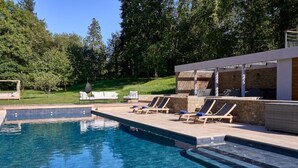 A swimming pool with lounge chairs and a covered seating area. - Suite Terrasse 2 at Domaine de la Commanderie de Ballan (Ballan-Miré)